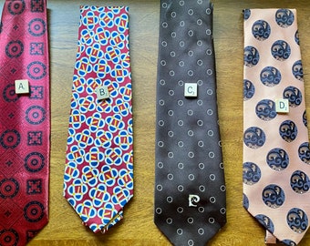 May include: Four different patterned neckties, labeled A, B, C, and D. Tie A is red with a black and white geometric pattern. Tie B is red, blue, and white with a geometric pattern. Tie C is brown with white polka dots. Tie D is pink with a blue and white pattern.