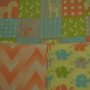 May include: Two fabric swatches, one with a chevron pattern in shades of peach and white, and the other with a repeating pattern of elephants in shades of blue, green, and yellow on a light yellow background.