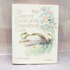 May include: The cover of a book titled "The Country Diary of an Edwardian Lady" by Edith Holden. The cover features a watercolor illustration of a willow warbler feeding its young.