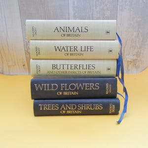 Könnte beinhalten: Ein Stapel von fünf alten Readers Digest-Büchern über die Tierwelt Großbritanniens. Die Bücher tragen die Titel "Animals of Britain", "Water Life of Britain", "Butterflies and Other Insects of Britain", "Wild Flowers of Britain" und "Trees and Shrubs of Britain".
