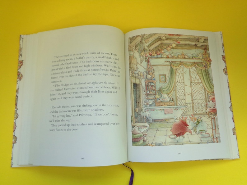 May include: An open book with colorful illustrations. The right page shows a detailed drawing of a bathroom with a bathtub, curtains, and small figures. The left page contains printed text. The book is on a yellow surface.
