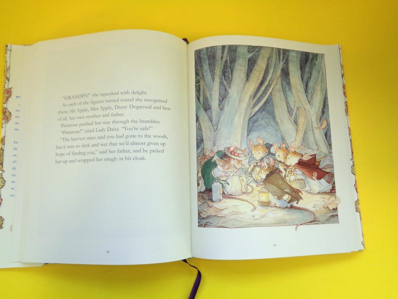 May include: An open book with a colorful illustration of mice in a forest setting. The illustration features several mice gathered around a lantern, with a backdrop of tall trees. Text is visible on the left page.