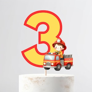 May include: A yellow number three cake topper with a red outline. A cartoon firefighter in a red truck is in front of the number. The topper is on a white cake.