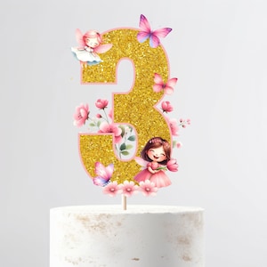Può includere: Topper per torta numero tre in glitter dorato con fiori rosa, farfalle e fate. Il numero tre è contornato di rosa.