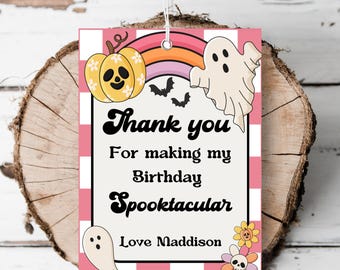 Może przedstawiać: Prostokątna etykieta prezentowa z motywem Halloween. Etykieta zawiera dynię, ducha, nietoperze i tęczę. Tekst na etykiecie brzmi "Thank you for making my birthday Spooktacular. Love Maddison."