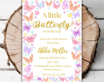 May include: A white baby shower invitation with a gold border and a butterfly theme. The invitation says "A little Butterfly is on the way" and includes the name "Abbie Miller".