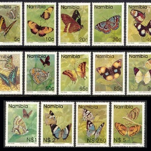 May include: A set of 12 vintage Namibian postage stamps featuring colorful butterfly illustrations. The stamps are arranged in three rows of four, with each stamp depicting a different butterfly species. The stamps are in excellent condition and would be a great addition to any stamp collection.