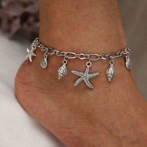 May include: Silver anklet with multiple charms, including seashells and a starfish.