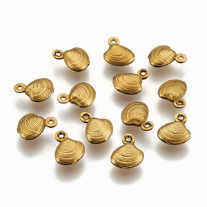 May include: A group of 14 gold-colored metal seashell charms with a textured surface. The charms have a small loop at the top for attaching to jewelry or other crafts.