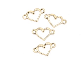 May include: Four gold-colored metal heart-shaped charms with open centers and two jump rings on each charm.
