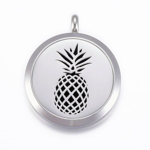 May include: Silver-toned metal locket with a cutout design of a pineapple. The locket has a hinged lid and a loop for attaching a chain.
