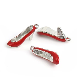 May include: Three red high heel shoe charms with silver metal accents. The charms have a loop at the top for attaching to a bracelet or necklace.
