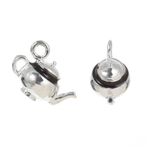 May include: Two silver teapot charms with black enamel accents. The teapot on the left has a spout and handle. The teapot on the right has a lid.
