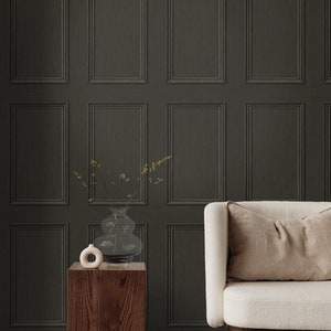 Op de afbeelding: Een donkergrijze houten lambrisering met een witte bank en een houten bijzettafel met een vaas met gedroogde bloemen. De bank heeft een beige kussen en een houten onderstel.