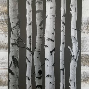 May include: A black and white abstract print of birch trees against a dark gray background. The trees are stylized and have a graphic design aesthetic.