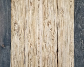 May include: A close-up of a wood paneling wall with a light brown wood grain pattern. The paneling is bordered by a dark blue wood trim.