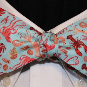 CRUSTACEAN COTILLION--Handmade bow tie in novelty cotton, lobsters, crabs, octopus, shrimp, peach, aqua, coral, for well dressed shell fish