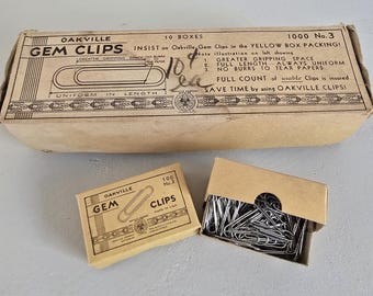 May include: An assortment of vintage Oakville Gem Clips in their original packaging. The image shows a large box labeled "10 Boxes" and two smaller boxes, one open, filled with silver metal paper clips. The boxes have text that reads "Greater Gripping Space" and "No Burrs to Tear Papers."