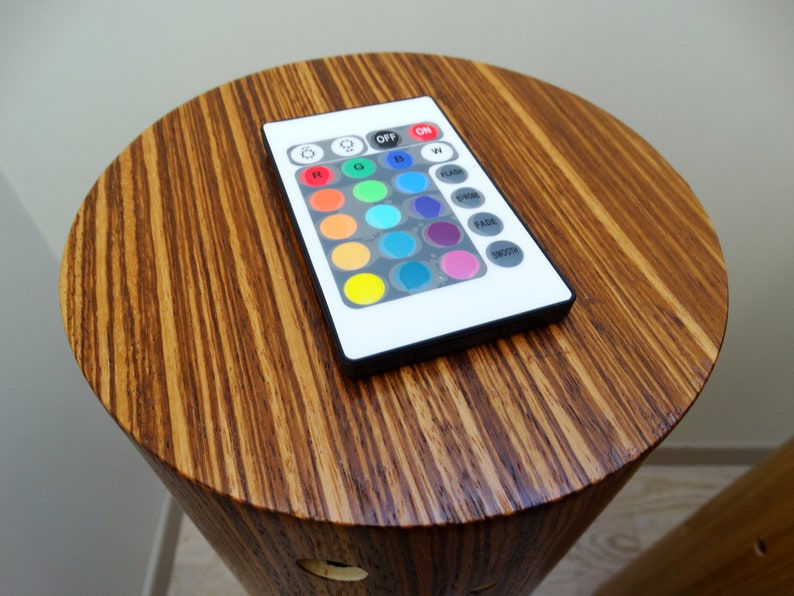 May include: A white remote control with a black border and 16 buttons. The buttons are labeled with various functions, including "ON", "OFF", "FLASH", "FADE", "SMOOTH", and "W". There are also 12 colored buttons.