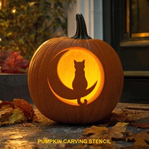 May include: A carved orange pumpkin featuring a cutout design of a cat sitting on a crescent moon. The interior is illuminated with a warm yellow light, casting a glow through the silhouette. The text PUMPKIN CARVING STENCIL is visible.