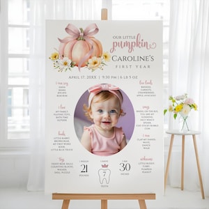 Puede incluir: Un letrero personalizado del primer cumpleaños con una foto de un bebé. El letrero incluye el texto "Our Little Pumpkin" y "Caroline's First Year". Enumera datos sobre el bebé, incluido su peso de 9,5 kg y su altura de 76 cm.
