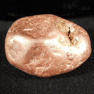 May include: A white ceramic mug with a black handle and the text "But First, Coffee" in a black, bold font. The mug is sitting on a wooden surface. The mug is approximately 4 inches tall.