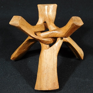 Puede incluir: Un soporte de madera con un diseño único e intrincado, perfecto para exhibir cristales u otros objetos pequeños. El soporte está hecho de madera natural y tiene un aspecto cálido y rústico.