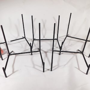 May include: Set of six black metal easel stands for displaying artwork or photos. The stands are made of thin metal and have a simple design.