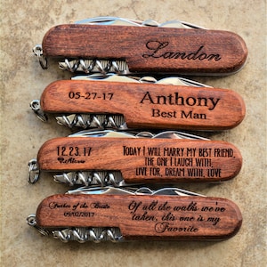 May include: Four wooden handled pocket knives with personalized engravings. The top knife reads "Landon". The second knife reads "05-27-17 Anthony Best Man". The third knife reads "12.23.17 Alexis TODAY I WILL MARRY MY BEST FRIEND, THE ONE I LAUGH WITH, LIVE FOR, DREAM WITH, LOVE". The bottom knife reads "Father of the Bride 09/02/2017 Of all the walks we've taken, this one is my Favorite".