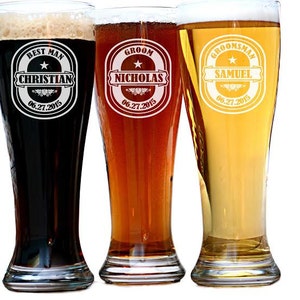 May include: Three tall beer glasses filled with different colored beers. Each glass has a personalized design with text. The first glass says "Best Man Christian 06.27.2015". The second glass says "Groom Nicholas 06.27.2015". The third glass says "Groomsman Samuel 06.27.2015".