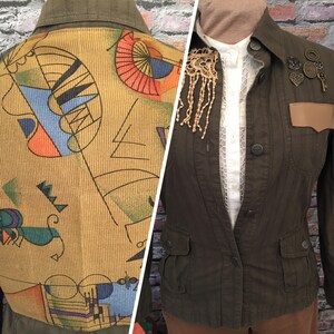 May include: A green corduroy jacket with a geometric pattern on the back. The jacket has a button closure and two pockets on the front.