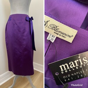 May include: A purple satin skirt with a bow at the waist. The skirt has a label that reads "Blumarine Made in Italy I 44 D 38" and another label that reads "maris COLLECTL OLD NAPLES, F 94 1 2 6 3".