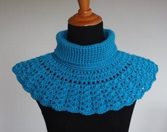 May include: A teal blue crocheted cowl with a high neck and a scalloped edge.