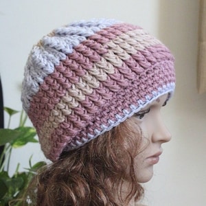 Op de afbeelding: Een gebreide beanie in tinten roze, beige en lichtblauw. De beanie heeft een slouchy pasvorm en is gemaakt met een textuur.