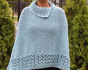 Op de afbeelding: Een lichtblauwe gehaakte poncho met een rolkraag en een decoratieve rand. De poncho is gemaakt met een eenvoudig steekpatroon en heeft een losse pasvorm.