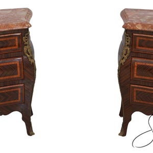 May include: Pair of antique French bombe chests with marble tops. Each chest features three drawers with brass hardware and decorative brass accents. The wood has a dark finish with a chevron pattern.