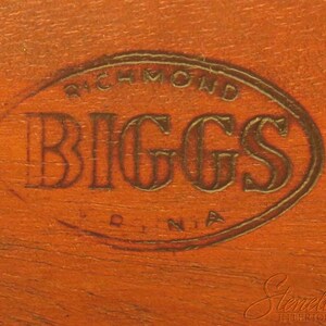 Pu&ograve; includere: Primo piano di una superficie in legno marrone con un timbro ovale dorato che recita "Richmond Biggs Virginia".