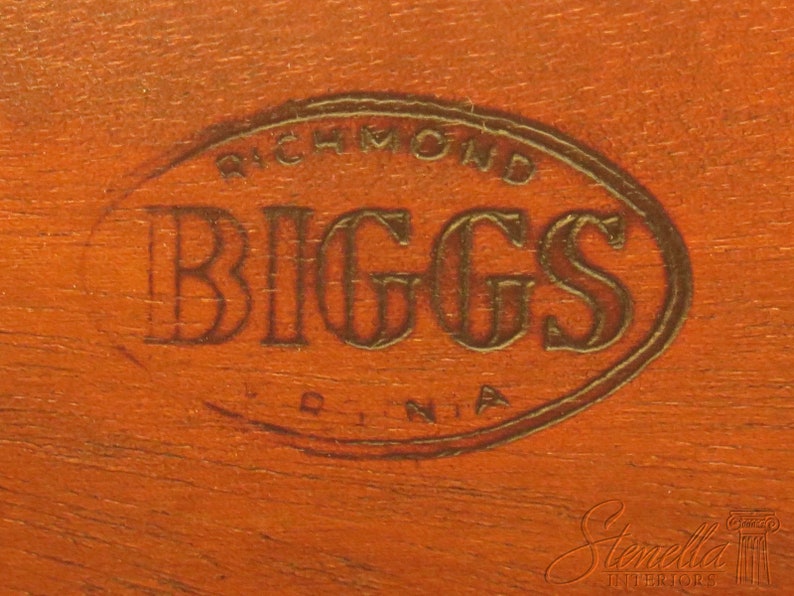 Pu&ograve; includere: Primo piano di una superficie in legno marrone con un timbro ovale dorato che recita "Richmond Biggs Virginia".