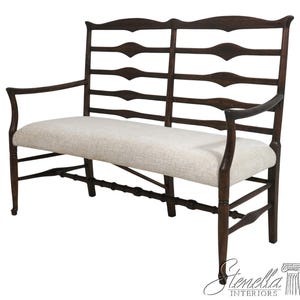 May include: A dark wood bench with a high back and armrests. The back features a series of horizontal, decorative cutouts. The seat is upholstered in a light-colored fabric. The bench has a classic, elegant design.