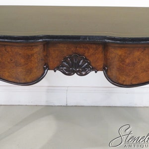 May include: A wooden console table with a dark brown finish and a curved top. The table has a black and gold trim and a carved detail on the front.