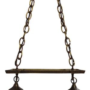 May include: A two-light pendant light fixture with a hammered metal finish and a chain suspension. The fixture has two iridescent glass shades.