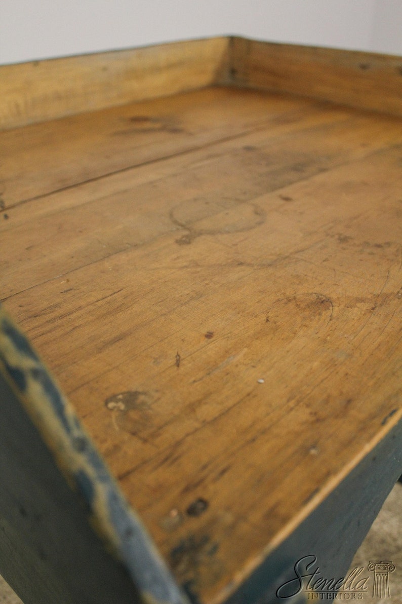 Op de afbeelding: Een houten dienblad met een blauw geverfd frame. Het dienblad heeft een versleten, rustieke uitstraling en is gemaakt van natuurlijk hout.