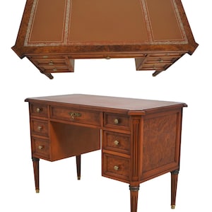 May include: A two-piece wooden desk with a brown leather top. The desk has multiple drawers with brass knobs and decorative legs. The top section has a leather surface with a decorative border. The desk is approximately 60 inches wide and 30 inches deep.