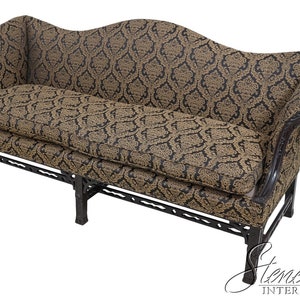May include: A black and gold patterned sofa with a curved back and wooden legs. The sofa is upholstered in a damask fabric.