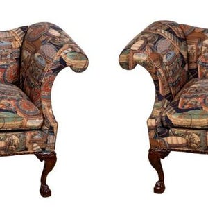 May include: Two upholstered sofas with a patterned fabric in shades of brown, green, and beige. The sofas have curved arms, a high back, and dark wooden legs. The overall design is classic and elegant.