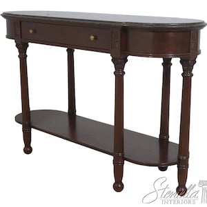 May include: A dark brown console table with a marble top and a lower shelf. The table has a drawer with two brass knobs and decorative carved details on the legs. The table is approximately 60 inches long.