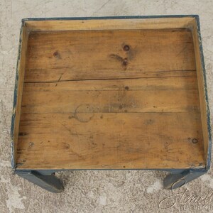 Op de afbeelding: Een houten tafel met een donkerblauw geverfd frame en poten. Het tafelblad is gemaakt van natuurlijk hout met een rustieke afwerking.
