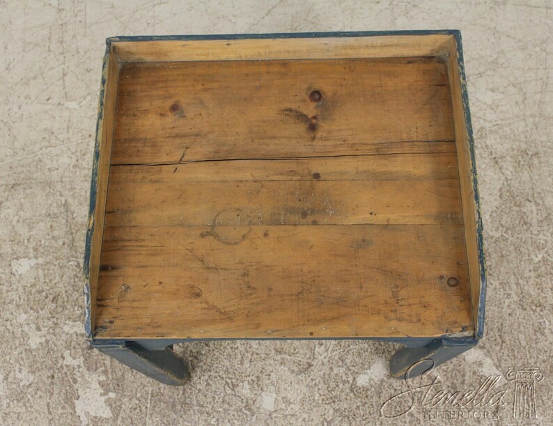 Op de afbeelding: Een houten tafel met een donkerblauw geverfd frame en poten. Het tafelblad is gemaakt van natuurlijk hout met een rustieke afwerking.