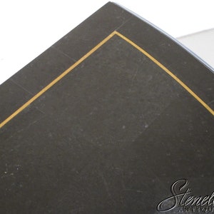 May include: Close-up of a black surface with a gold trim. The surface is slightly textured and has a subtle sheen.