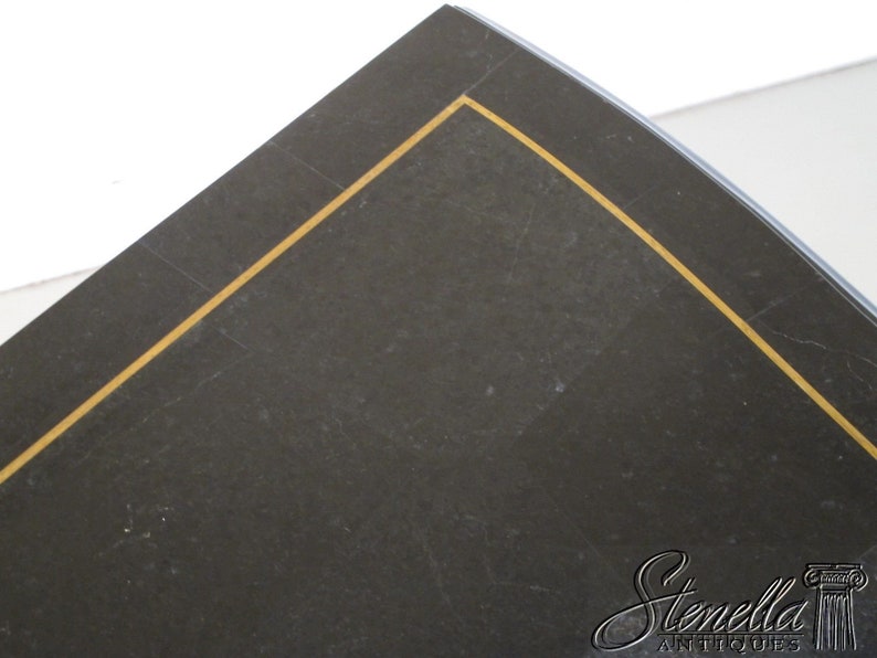 May include: Close-up of a black surface with a gold trim. The surface is slightly textured and has a subtle sheen.